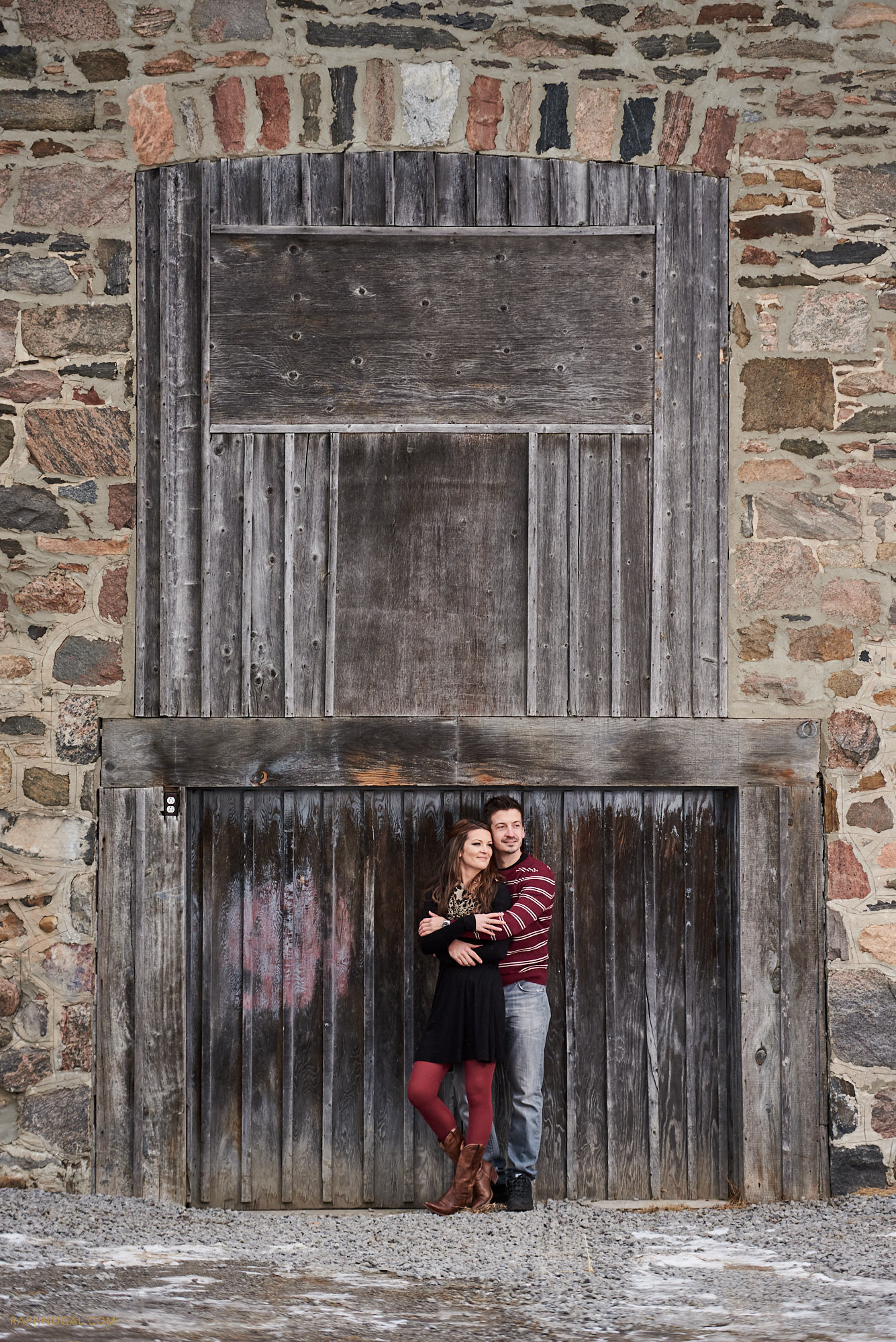 Couple against wooden door at Stonewood Equestrian