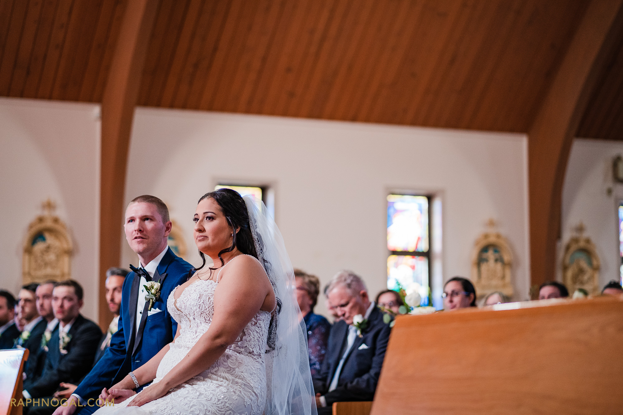 Bride and Groom sit at church listening to priest