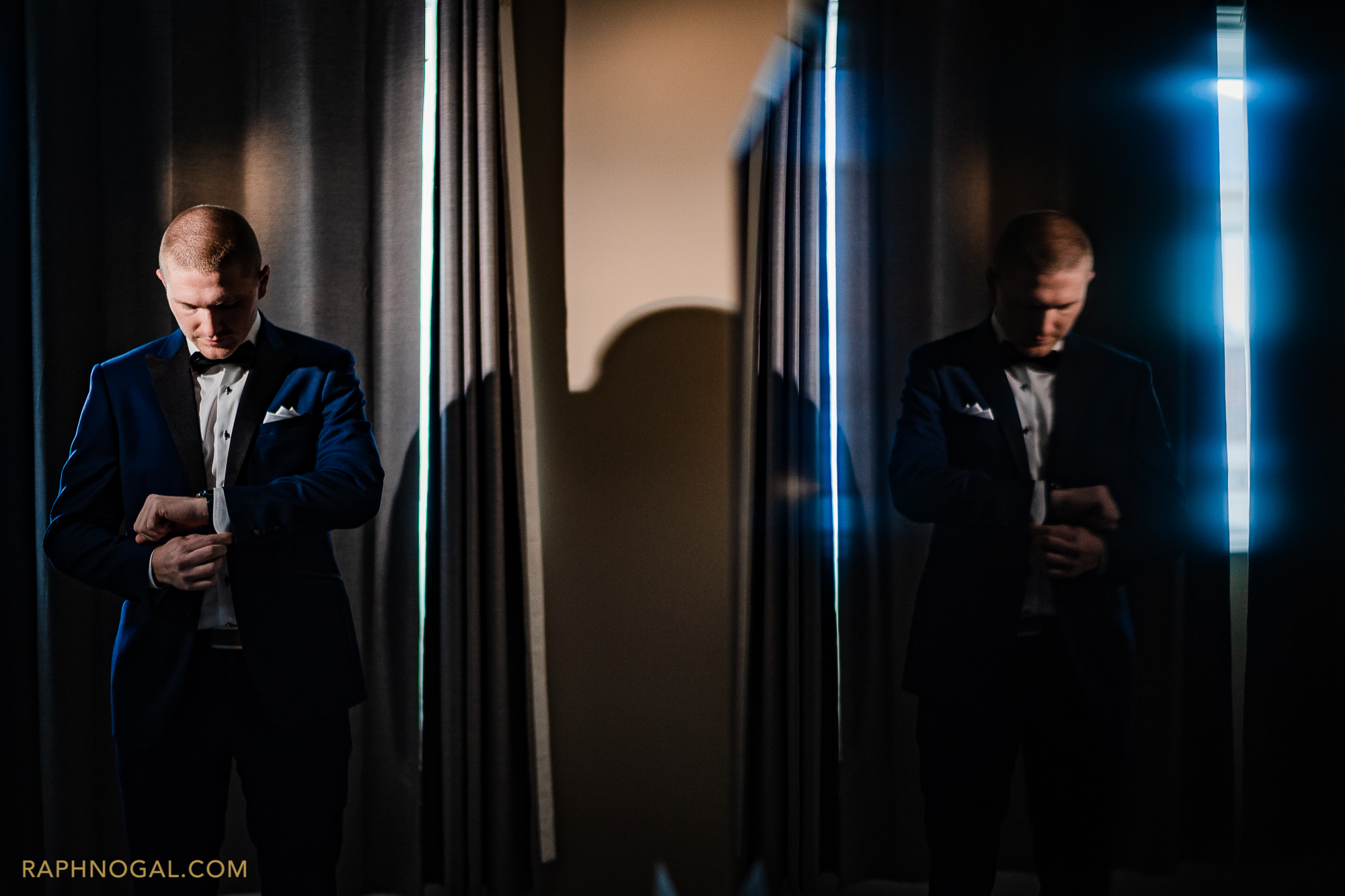 Groom putting on cufflinks, reflected in a TV screen