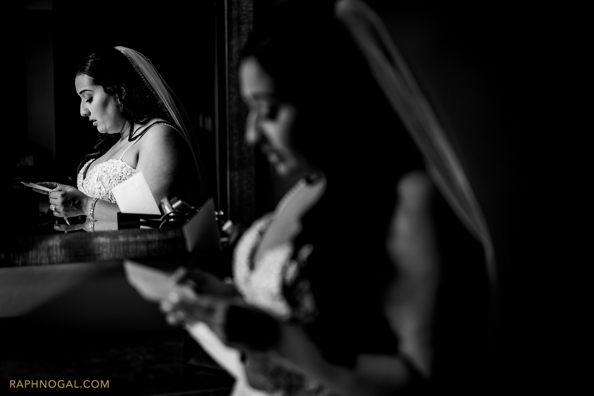 Bride reading card, reflected in the mirror