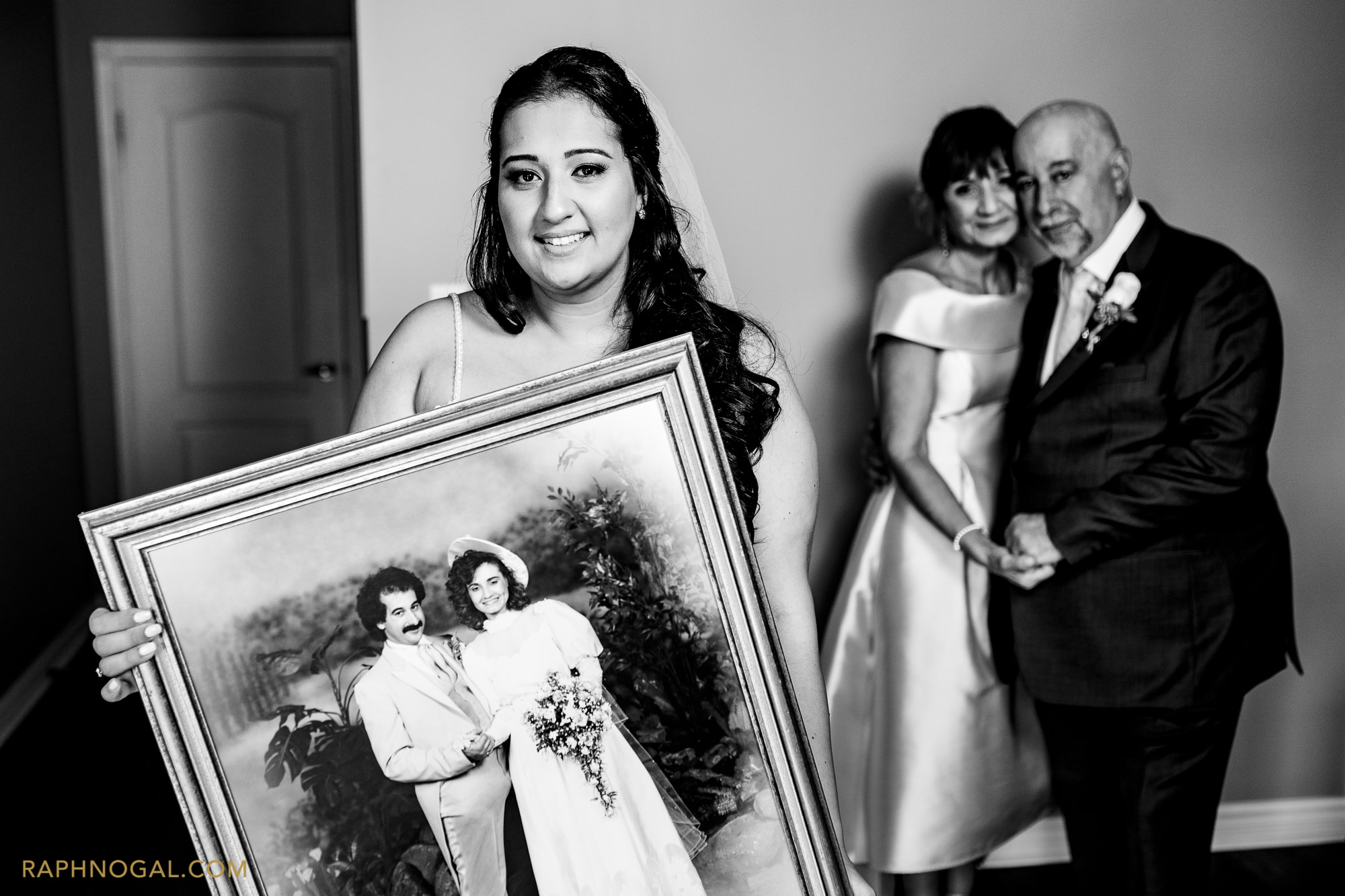 Bride holding photo of parents' wedding day 